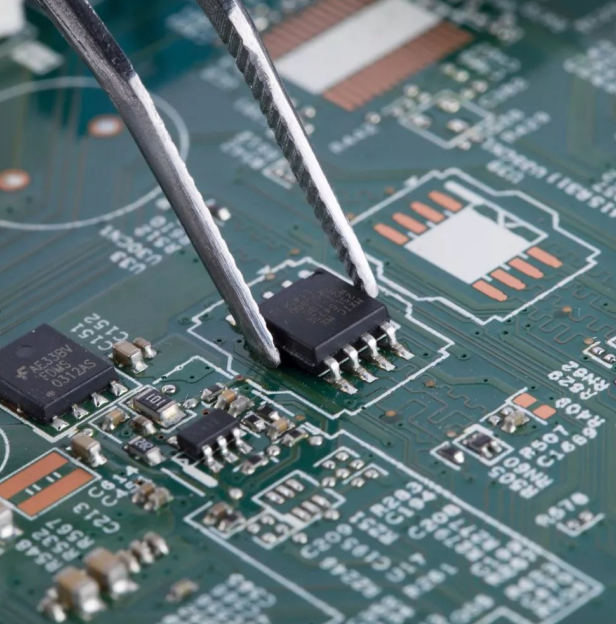 Tweezers placing green SMD chip onto circuit board