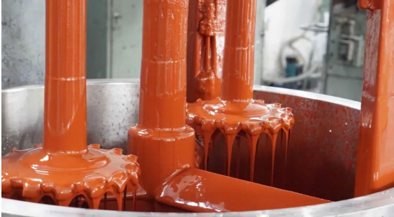 Close-up of orange epoxy adhesive being poured, showing its thick gel-like texture